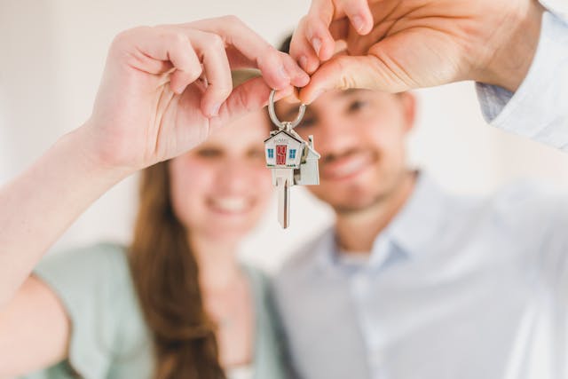 A couple holding up their new house keys.