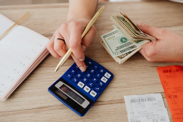 A person using a calculator to count money.