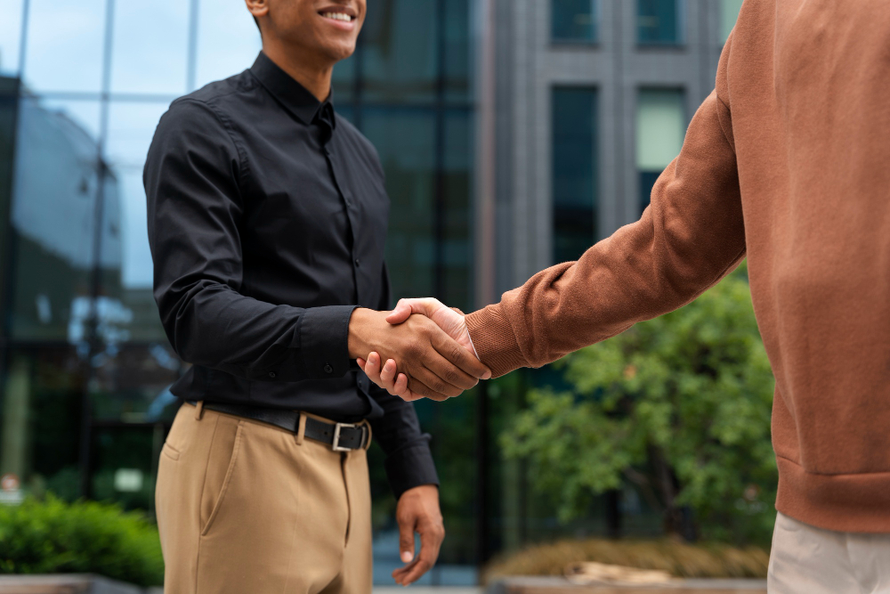 two people shaking hands outside