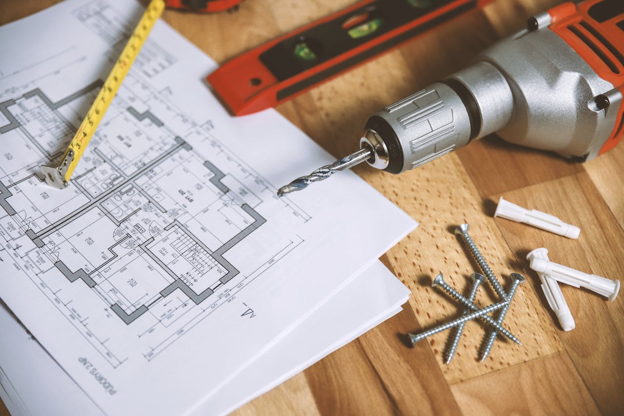 screwdriver-with-nails-and-home-building-plan