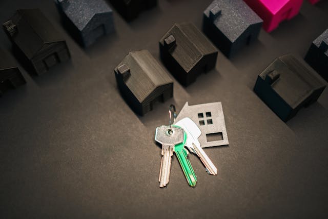 house keys next to small house figurines