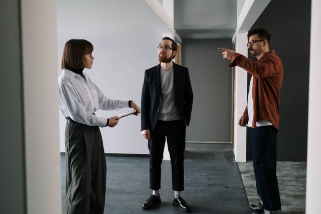 three people talking in a vacant apartment
