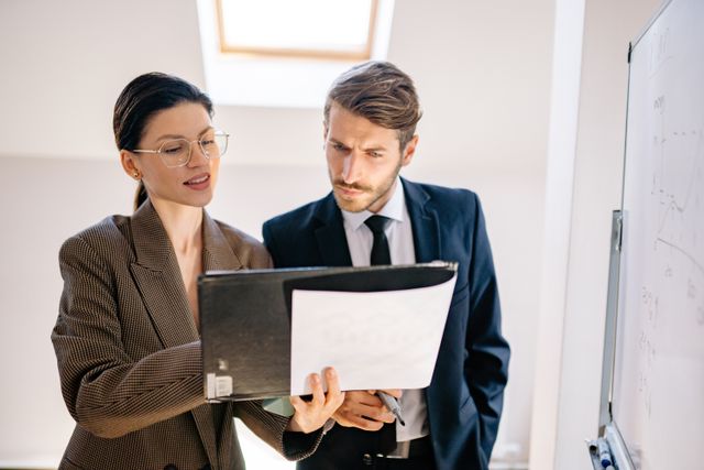 two people consulting a folder together