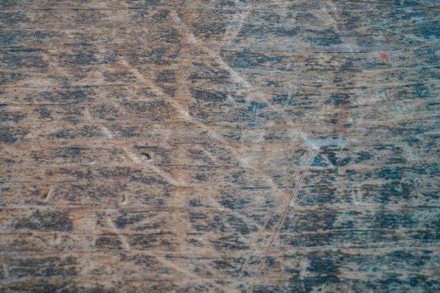 a wooden surface covered in scratches and scuffs